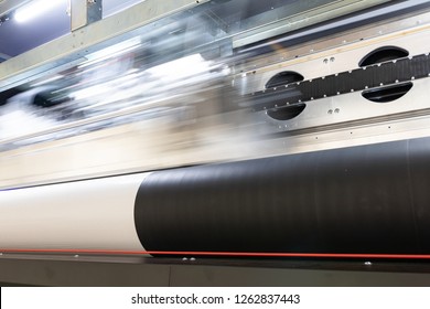 Details From The Inside Of A Large Scale Professional Printer, Print Head Passing By At Great Speed Over Vinyl Rolls During Production Hours. 