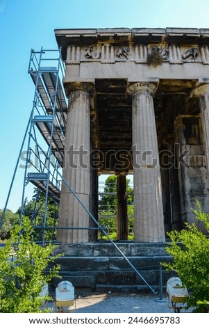 Details of the majestic, beautiful Temple of Hephaestus. Preserved friezes with relief images are visible on the architectural elements. The grandeur of the Doric columns and ceiling can be seen.