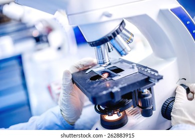 Details of medical laboratory, scientist hands using microscope for chemistry test samples