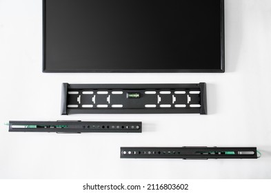 Details Of A Metal TV Wall Mounting Bracket And Computer Monitor Or TV Screen On White Background. Concept Of Mounting A Modern TV Screen Or Monitor On The Wall In An Apartment Or Hotel. Close-up