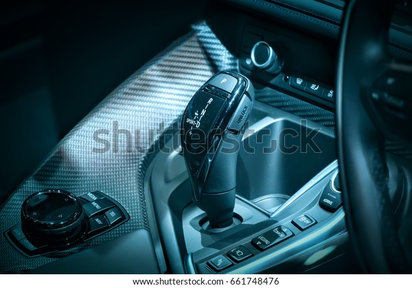 Details of modern automotive interior with\
selective focus. Automatic transmission and control panel inside\
expensive lux car. Blue lights\
colors.