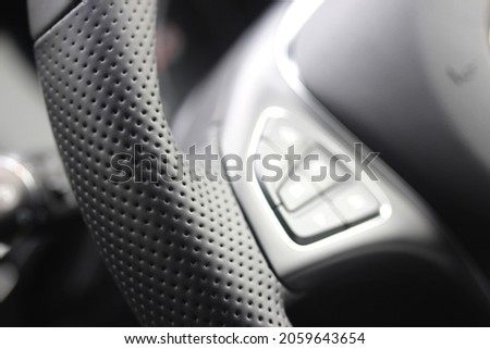 Details of a perforated leather steering wheel in a modern sports car