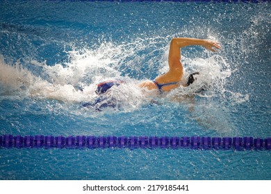 Details With A Professional Female Athlete Swimming In A Competition Swimming Pool.