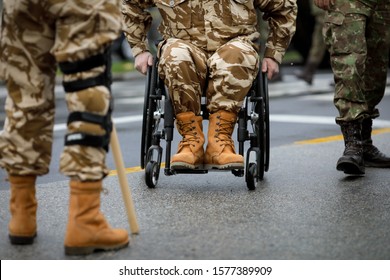 Details With A Romanian Army Veteran Soldier, Injured And Disabled, Sitting In A Wheelchair Dressed In His Military Desert Camouflage Uniform.