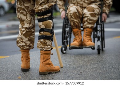 Details With A Romanian Army Veteran Soldier, Injured And Disabled, Sitting In A Wheelchair Dressed In His Military Desert Camouflage Uniform.