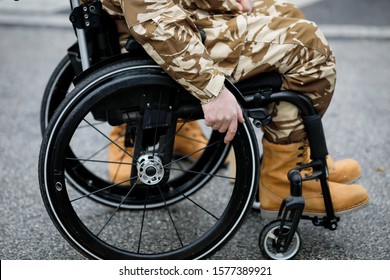 Details With A Romanian Army Veteran Soldier, Injured And Disabled, Sitting In A Wheelchair Dressed In His Military Desert Camouflage Uniform.