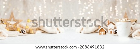 Details of Still life, cup of coffee with marshmallows, wooden decor, candle, Christmas lights with sweater on white background, home decor in cozy house. Banner for Winter weekend concept. 