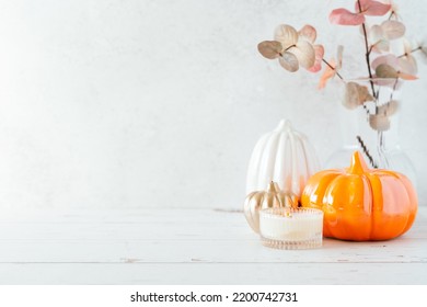 Details of Still life, pumpkins, candle, brunch with leaves on white table background, home decor in a cozy house. Autumn weekend concept. Fallen leaves and home decoration - Powered by Shutterstock