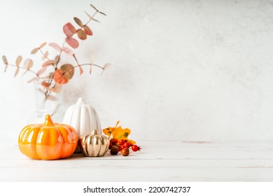 Details of Still life, pumpkins, candle, brunch with leaves on white table background, home decor in a cozy house. Autumn weekend concept. Fallen leaves and home decoration - Shutterstock ID 2200742737