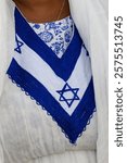 Details of a traditional Ethiopian kemis, a white dress with colorful embroidery, including here with a blue, Jewish star of Davd, worn by women during the Jewish holiday of Sigd in Israel. 