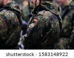 Details with the uniform and the flag on it of a German soldier taking part at the Romanian National Day military parade.