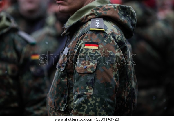 Details\
with the uniform and the flag on it of a German soldier taking part\
at the Romanian National Day military\
parade.