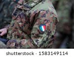 Details with the uniform and the flag on it of an Italian soldier taking part at the Romanian National Day military parade.