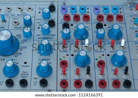 Detailshot of colorful knobs and switches from a modular synthesizer.