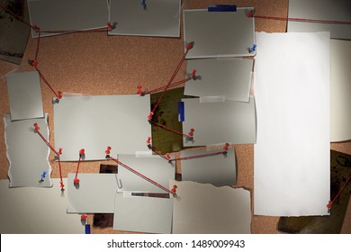 Detective board with photos of suspected criminals, crime scenes and evidence with red threads - Shutterstock ID 1489009943