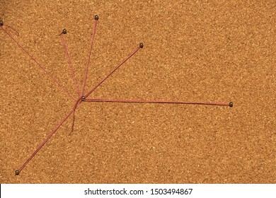 Detective concept with red thread connects pins on cork board from above
