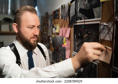 Detective Looking At Board With Fingerprints, Photos, Map And Clues Connected By Red String On Wall, Working In Office