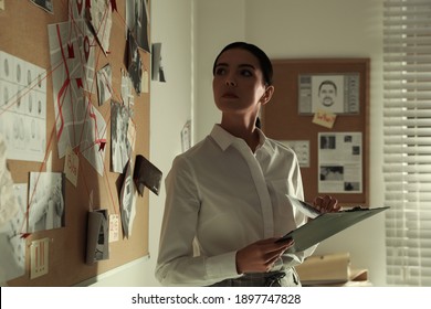 Detective Looking At Evidence Board In Office