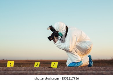 Detective studying a crime scene taking photographs.