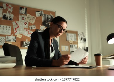 Detective working at desk in her office - Shutterstock ID 1897747822
