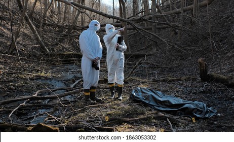 Detectives are collecting evidence in a crime scene. Forensic specialists are making expertise. Police investigation in a forest. - Shutterstock ID 1863053302