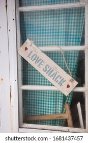 Detelict Beach Hut With Hand Painted Love Shack Sign