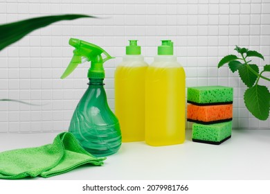 Detergent for dishes with mint and orange. Luminous aroma. Dish washing concept. Close up of  for dish washing on the kitchen countertop. Bottle and faucet in background