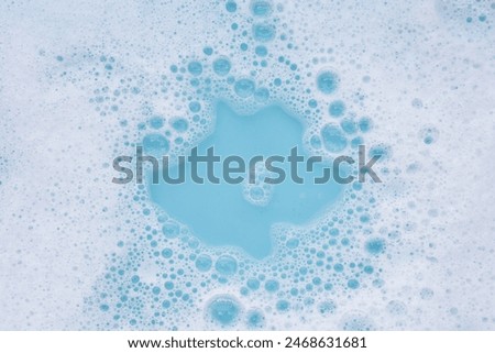 Detergent foam bubble on water. Blue background, Soap sud