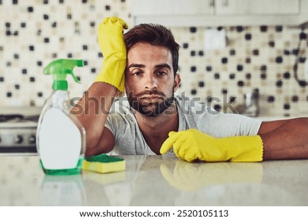 Detergent, sponge and bored man in kitchen at home for sanitizing germs, bacteria or dirt removal. Gloves, housekeeping and portrait of male person cleaning for hygiene of dust in apartment.