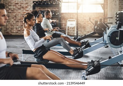 Determination keeps the fitness dream alive. Shot of a group of young people working out with rowing machines in the gym. - Powered by Shutterstock