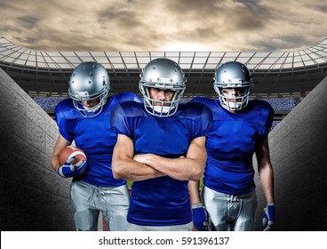 Determined American Football Players Standing Against Stadium In Background