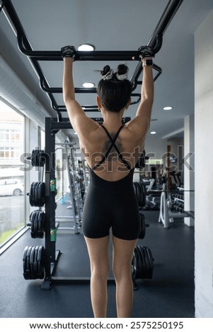 Similar – Image, Stock Photo Determined woman performing pull-up exercise at gym