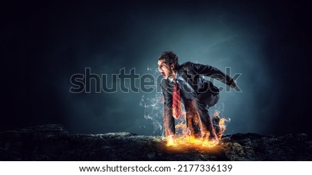 Determined businessman leaving fire trails on asphalt