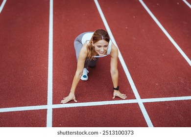 A determined female athlete prepares to start a sprint on a track. She exudes focus and energy, embodying the spirit of competition and fitness. - Powered by Shutterstock