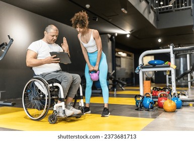 A determined fitness instructor in a wheelchair, train his dedicated female client, using a tablet to show a weekly workout plan.	 - Powered by Shutterstock