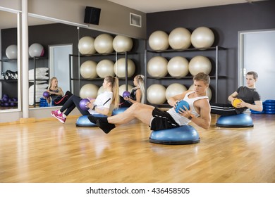 Determined Friends Exercising With Medicine Ball In Gym - Powered by Shutterstock