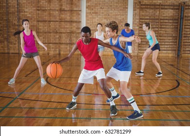 Determined high school kids playing basketball in the court