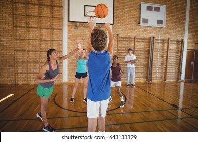 Determined High School Kids Playing Basketball In The Court