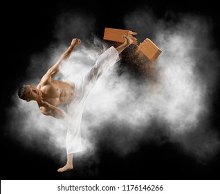 Determined Karate Man Breaking With Leg Wooden Board