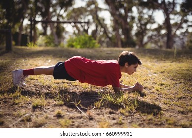 Determined Kid Exercising During Obstacle Course In Boot Camp