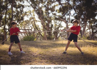 Determined kids practicing tug of war during obstacle course in boot camp - Powered by Shutterstock