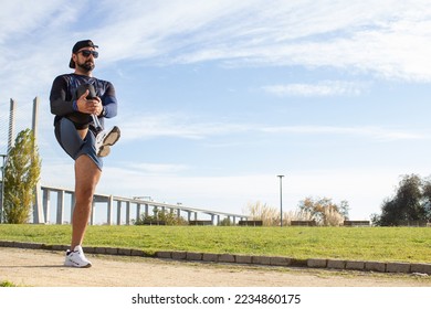 Determined man with artificial leg getting ready for jog. Man in sport clothes stretching in park on summer day, exercising. Sport, training, wellbeing, disability concept - Powered by Shutterstock