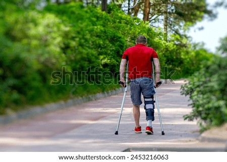 Image, Stock Photo Man with crutches or walking sticks leans back and supports himself on wet gray asphalt at the Golden Oldies classic car meeting in Wettenberg Krofdorf-Gleiberg near Giessen in Hesse in black and white
