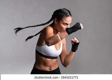 Determined middle aged woman boxer preparing for boxing fight. Fitness mid adult woman preparing for boxing training at gym. Beautiful strong sportswoman in boxing gloves prepared right hand punch. - Powered by Shutterstock