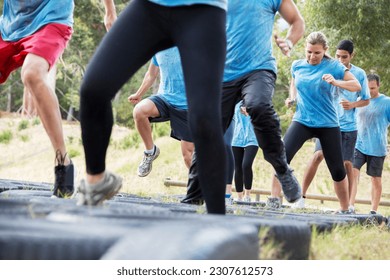 Determined people jumping tires on boot camp obstacle course - Powered by Shutterstock