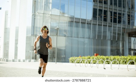 A determined runner dashes through a modern city, bright sun highlighting sleek buildings and greenery around him.