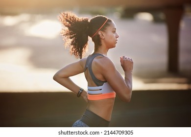 Determined To Set A Personal Best. Cropped Shot Of An Attractive Young Woman Taking A Run Through The City.