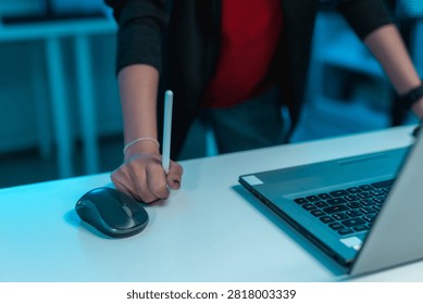 Determined software developer gripping a digital pen beside laptop while solving complex coding challenges, representing problem solving, programming, innovation and productivity.