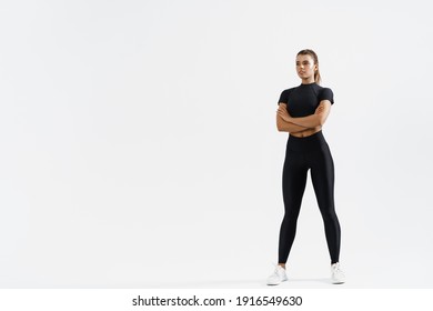 Determined sports woman in sport clothing standing on white background with crossed arms. Confident fitness female looking away, training and exercising concept. - Powered by Shutterstock