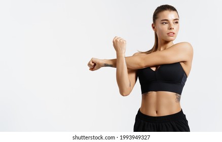 Determined, strong and healthy sports woman, stretching, stretch her arms, warm up for workout in gym, looking away. Silhouette of young athlete prepare body for exercises, white background - Powered by Shutterstock